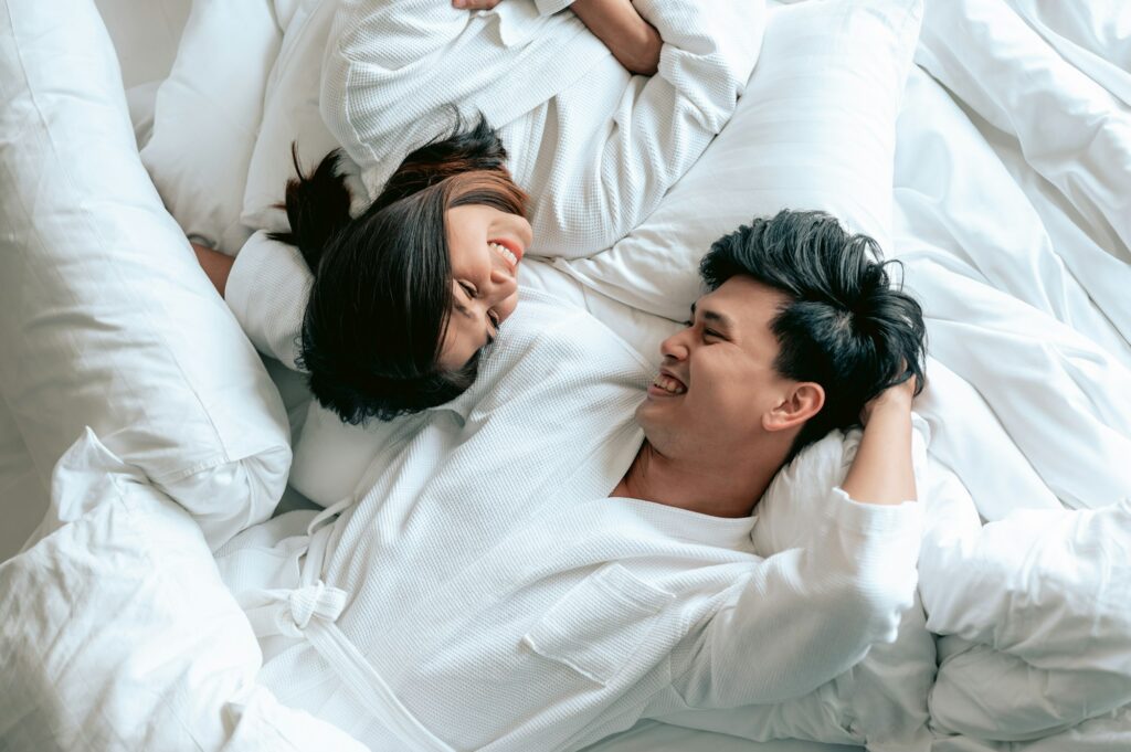 Asian couples is laying on bed in the bed room at modern home.Couple in Valentine day.Love couple